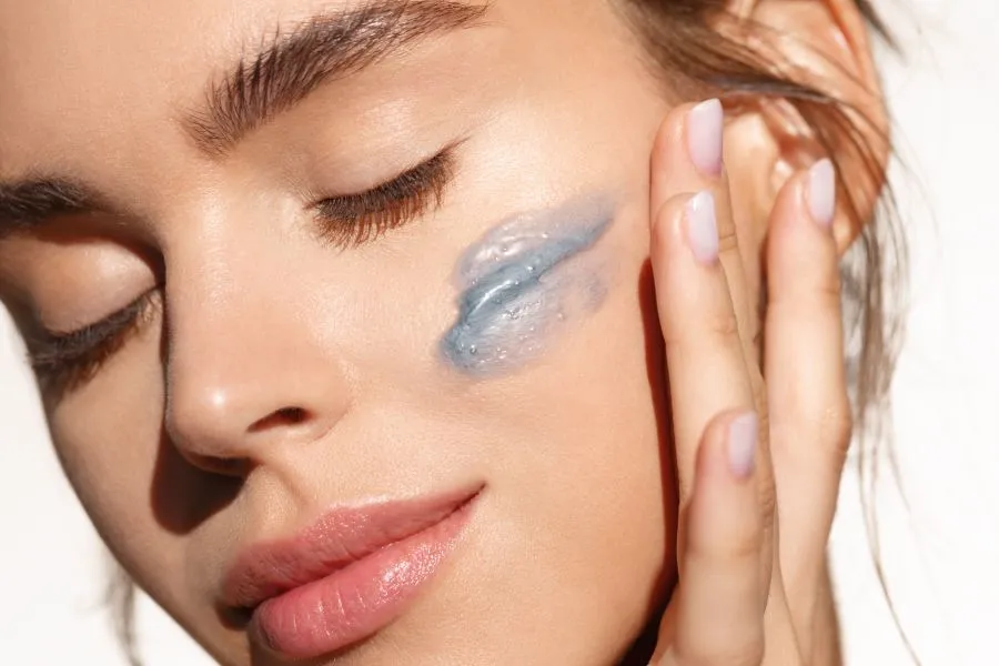 A woman with a swipe of cream on her cheek.
